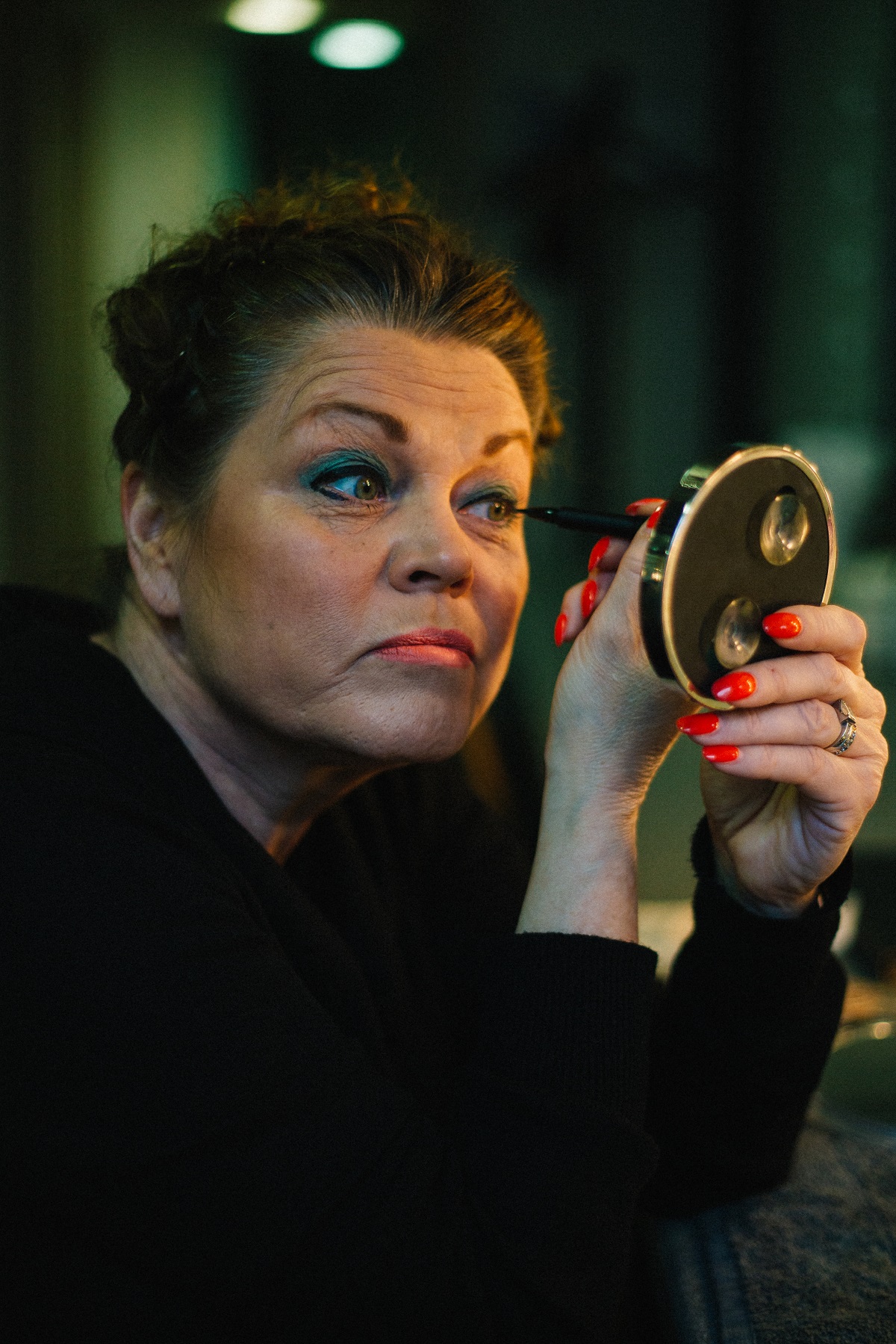 A photograph of actress Vicki Entwistle applying make-up from the Dressing Room No.1 exhibition.