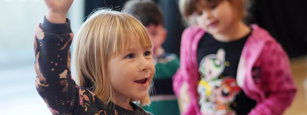 A young person dances as two young people look on in a promotional image for Bishop Auckland Town Hall Youth Theatre.