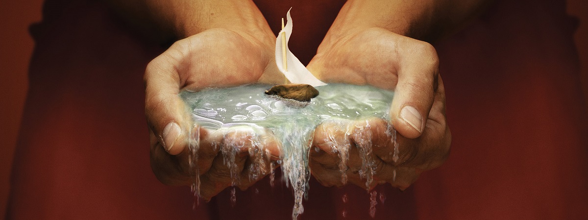 Two hands hold water with a small boat in a promotional image for the RSC's The Tempest.