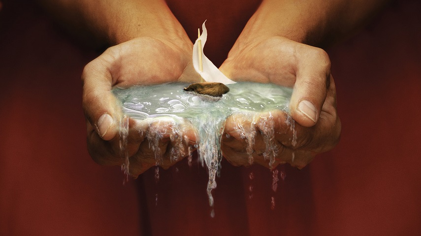 Two hands hold water with a small boat in a promotional image for the RSC's The Tempest.