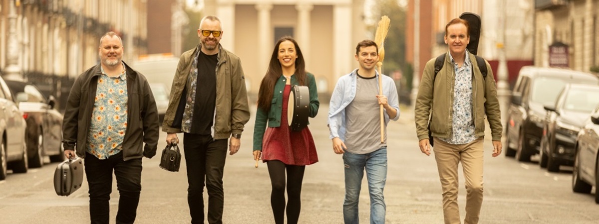 The Irish House Party band walking in the street.