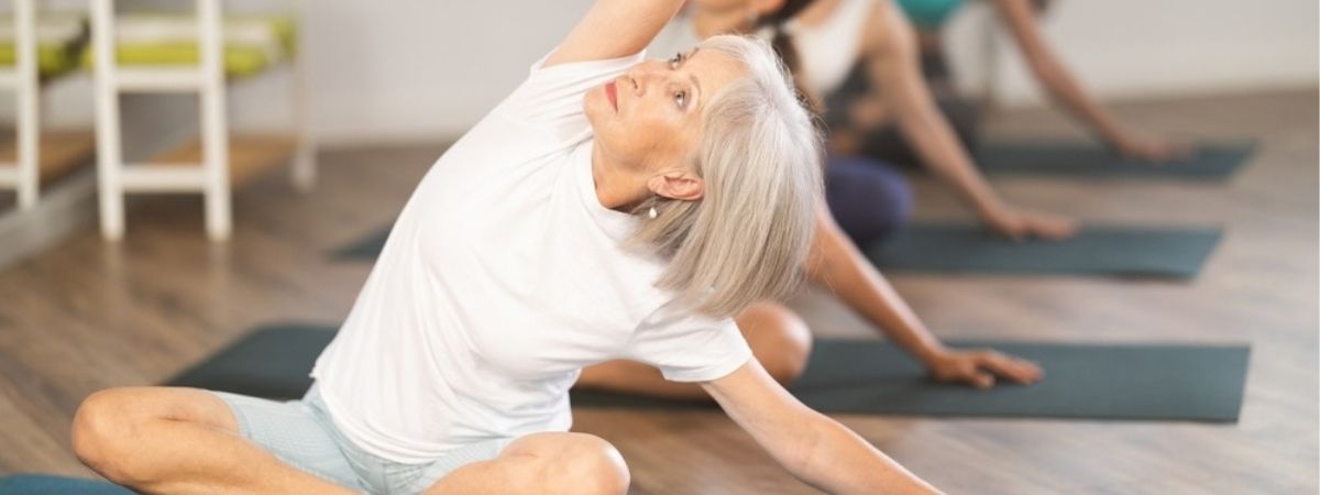 Group of people can be seen taking part in a yoga session